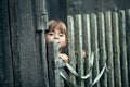 Little cute funny girl near vintage rural fence.