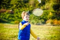 Little cute funny kid boy with badminton racquet playing in park on warm summer spring day. Active outdoors games and leisure for Royalty Free Stock Photo