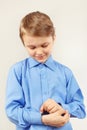 Little cute gentleman fastened the buttons on sleeve bright shirt