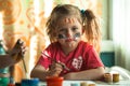 Little cute girl artist with paint of the face in her home. Royalty Free Stock Photo