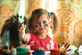 Little cute girl artist with paint of face. Royalty Free Stock Photo
