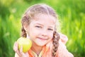 Little cute girl on a background of green grass with an apple Royalty Free Stock Photo