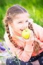 Little cute girl on a background of green grass with an apple Royalty Free Stock Photo