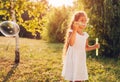 Little cute girl blowing bubbles in spring park. Kid having fun playing games outdoors. Children activities Royalty Free Stock Photo