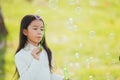 Little cute girl child having fun and enjoying outdoor play blowing soap bubbles Royalty Free Stock Photo