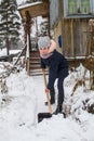 Little girl cleans snow to shovel near the country house. Royalty Free Stock Photo