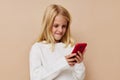 Little cute girl communication smartphone entertainment on a beige background