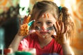 Little cute girl drawing paint with paint of face. Royalty Free Stock Photo
