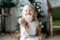 A little cute girl dreams of gifts. Girl making a wish. Merry Christmas and Happy Holidays