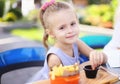 Little cute girl eating rench fries with sauce at street cafe outside. Royalty Free Stock Photo