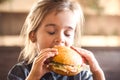 A little girl eats a sandwich in a cafe Royalty Free Stock Photo