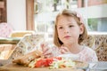 Little Cute Girl Eating Toast with Salad at Breakfast Royalty Free Stock Photo
