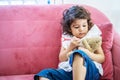 Little cute girl enjoy playing toy injection syringes toy on the teddy bear on the sofa in the home, education time at home Royalty Free Stock Photo