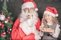 Little cute girl feeding Santa cookies and milk at Christmas