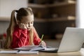 Little cute girl feeling tired and sleepy while doing her homework Royalty Free Stock Photo