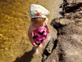 Little cute girl in full growth standing in shallow water in the river