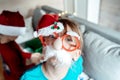 Little cute girl in funny glasses with nose, red Christmas santa claus hat. Congratulations,greetings. Kids, children playing on Royalty Free Stock Photo