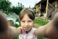 Little cute girl funny taking a selfie out in the viilage house.