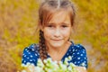 Little cute girl gathers a bouquet of wild flowers on a summer day in the field Royalty Free Stock Photo