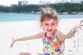 A little cute girl with glasses is playing in the sand on the beach by the sea Royalty Free Stock Photo