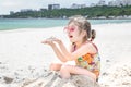 A little cute girl with glasses is playing in the sand on the beach by the sea Royalty Free Stock Photo