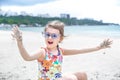 A little cute girl with glasses is playing in the sand on the beach by the sea Royalty Free Stock Photo