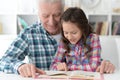 Little cute girl with grandfather reading book Royalty Free Stock Photo