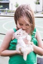 Little cute girl in a green T-shirt hugs Persian kitten light color Royalty Free Stock Photo