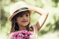 Little cute girl in a hat holding a bouquet of flowers Royalty Free Stock Photo