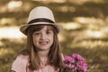 Little cute girl in a hat holding a bouquet of flowers Royalty Free Stock Photo