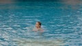 The little cute girl have fun in the pool. The child enjoy summer vacation in a swimming pool jumping, spinning, splash water. Royalty Free Stock Photo