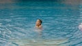 The little cute girl have fun in the pool. The child enjoy summer vacation in a swimming pool jumping, spinning, splash Royalty Free Stock Photo