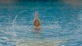 The little cute girl have fun in the pool. The child enjoy summer vacation in a swimming pool jumping, spinning, splash water. Royalty Free Stock Photo