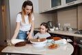 Little cute girl and her mother baking cake for daddy Royalty Free Stock Photo