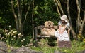 Little cute girl with her teddy bear sitting on a wooden bench i Royalty Free Stock Photo