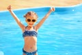 Little cute girl holding hands up near a swimming pool Royalty Free Stock Photo