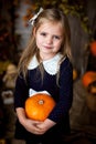 Beautiful little girl holding a pumpkin