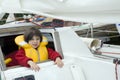 Little cute girl in life jacket on yacht