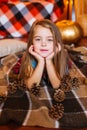 Little cute girl with long curly hair near the swing and pumpkins in a red in a plaid dress Royalty Free Stock Photo