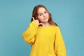 Little cute girl making call with fingers shaped like telephone near head, communicating by phone. Royalty Free Stock Photo