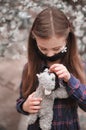 Little cute girl in mask has fun outdoors with her best friend toy cat. Royalty Free Stock Photo