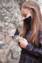 Little cute girl in mask has fun outdoors with her best friend toy cat. Royalty Free Stock Photo