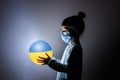 Little cute girl in medical mask holding a luminous planet Earth in her hands. Coronavirus in Ukraine. covid-19 concept