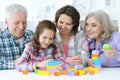 Little cute girl with mother and grandparents playing together