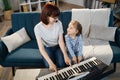 Little cute girl with music teacher having lesson at piano at school of music. Royalty Free Stock Photo