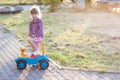 Little cute girl outdoors with a toy car on a sunny day Royalty Free Stock Photo