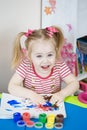 Little cute girl paints with fingers Royalty Free Stock Photo