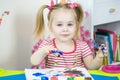 Little cute girl paints with fingers Royalty Free Stock Photo