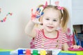 Little cute girl paints with fingers Royalty Free Stock Photo