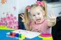 Little cute girl paints with fingers Royalty Free Stock Photo